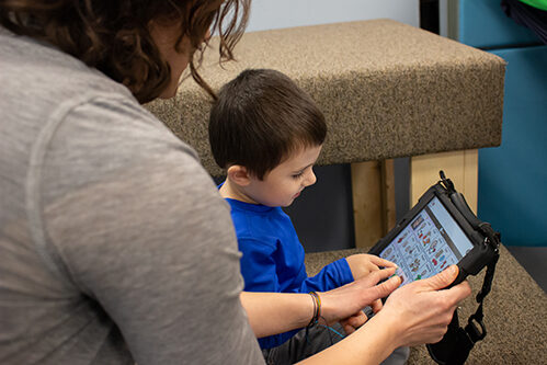 Woman using an Ipad with a young boy