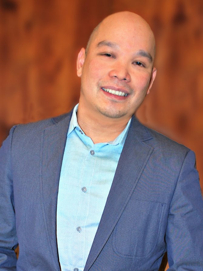 Lim_002b Male smiling and wearing a blue dress jacket