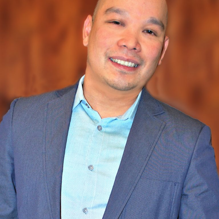 Lim_002b Male smiling and wearing a blue dress jacket