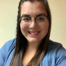 Kels-225×300 Smiling photo of woman with brown hair and glasses