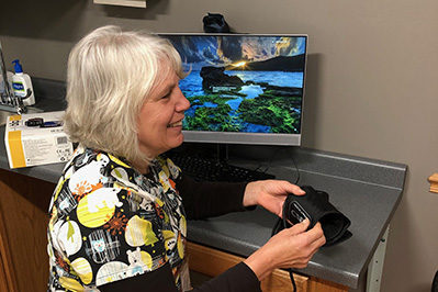 Female provider smiling and holding blood pressure cuff