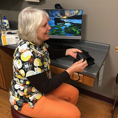 Blood-Pressure-Monitoring_web Female provider smiling and holding blood pressure cuff
