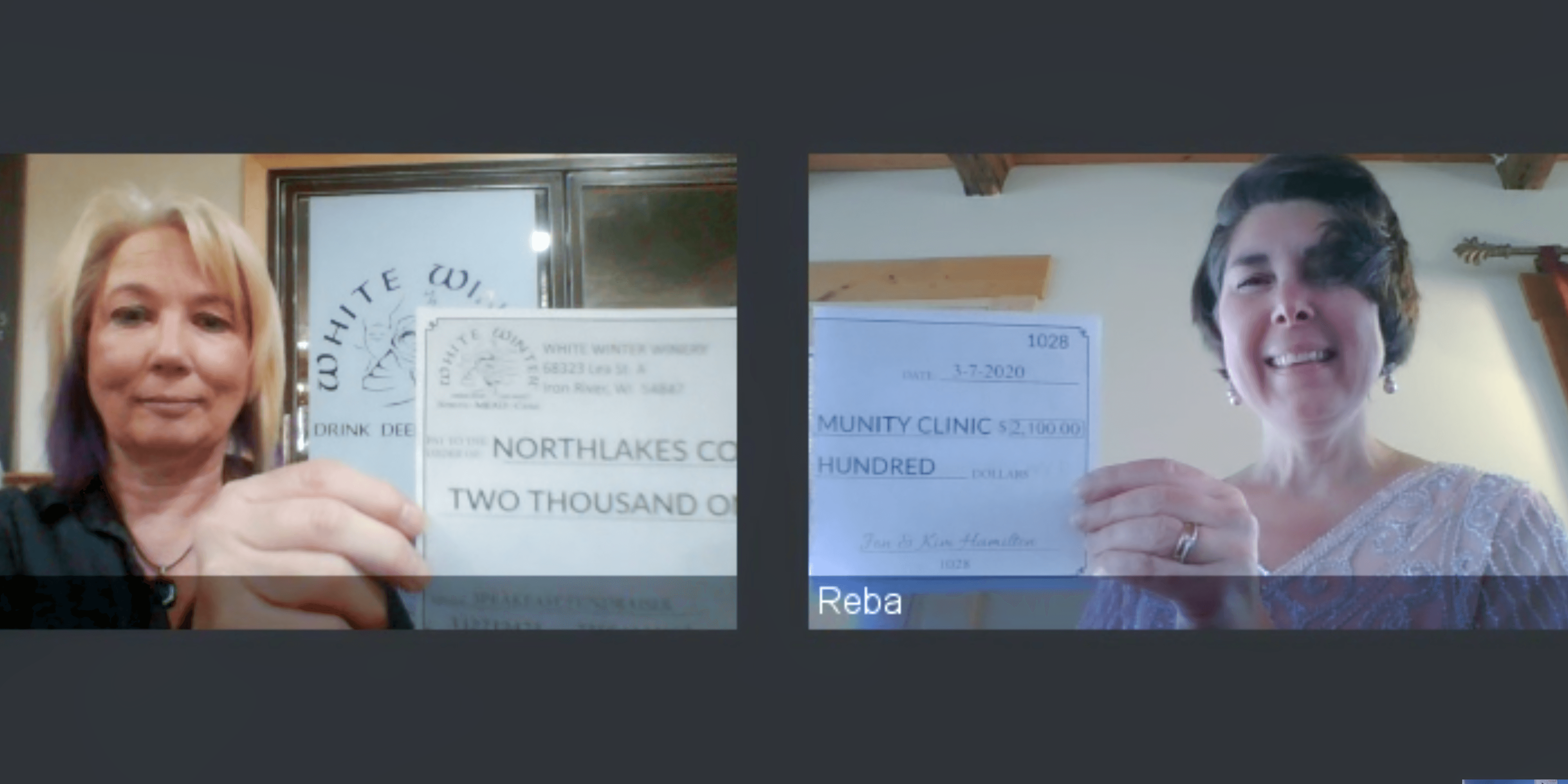 Two women on online meeting holding up a check