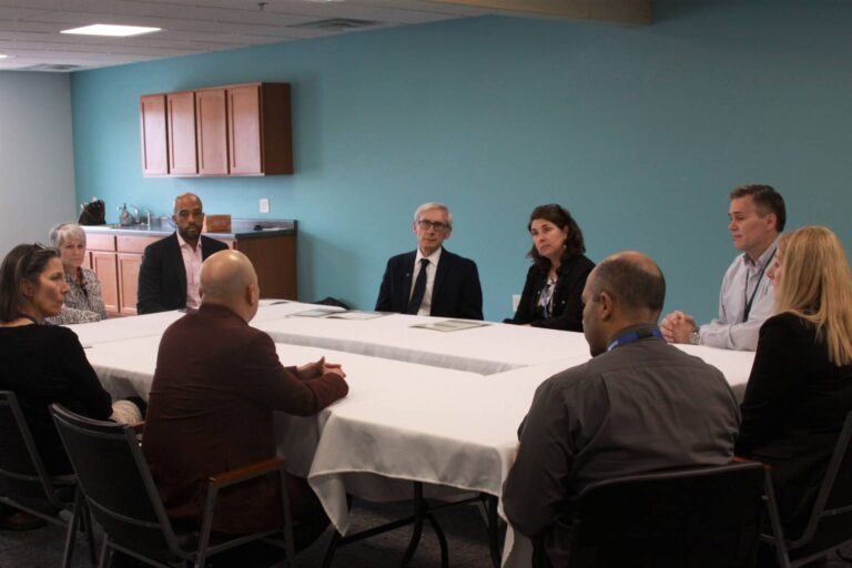 NorthLakes staff sitting at banquet table talking with Tony Evers