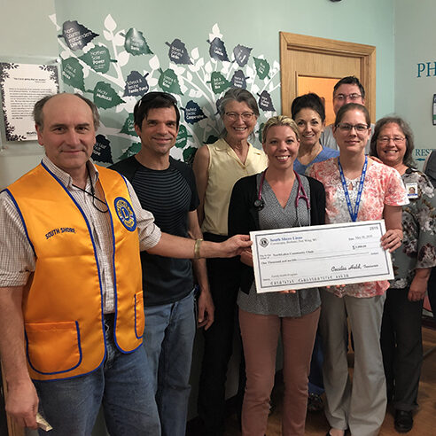 LionsCheck Staff members holding a check and smiling