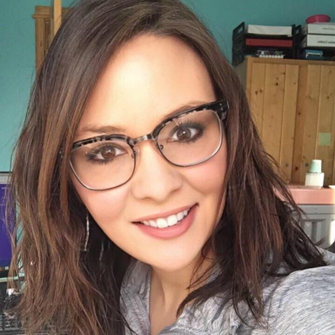 desk Woman smiling with long brown hair and glasses