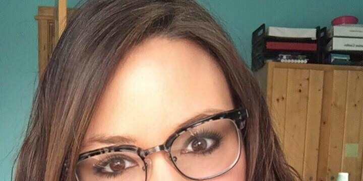 desk Woman smiling with long brown hair and glasses