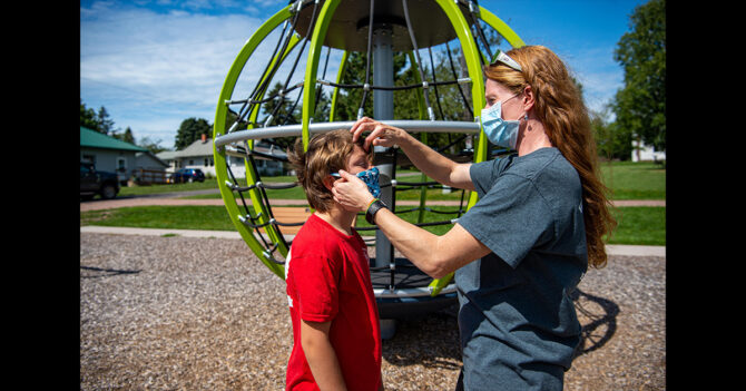 Mom and Son Woman with mask on adjusting her son's mask