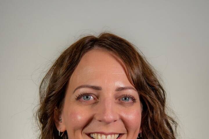 Woman with wavy brown hair and turtleneck sweater