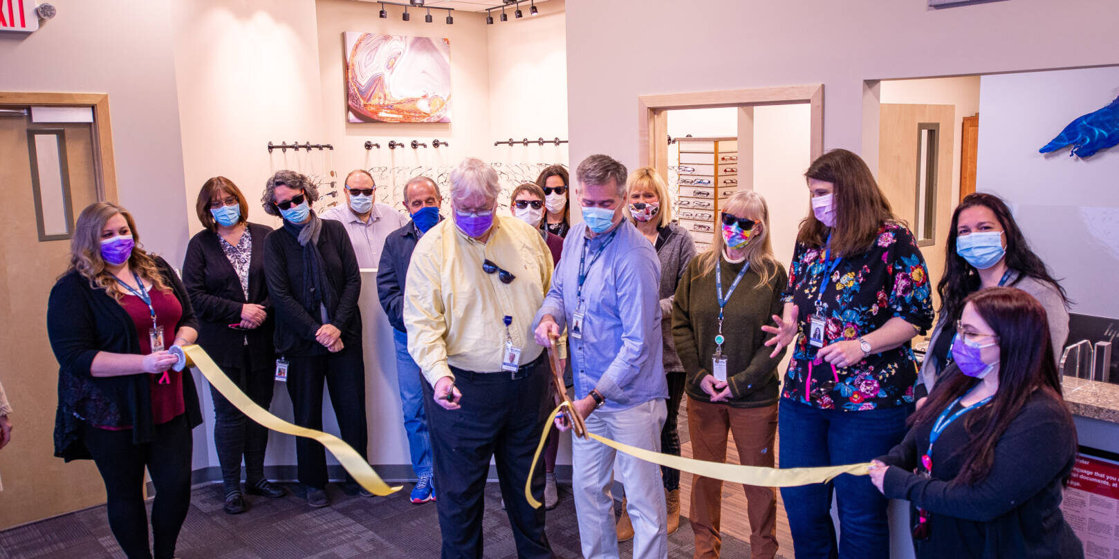 Staff members watching ribbon be cut at Downtown Ashland clinic in the Eye center