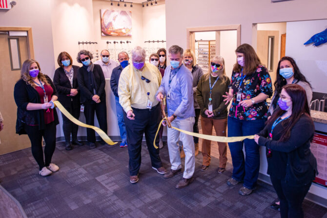 Staff members watching ribbon be cut at Downtown Ashland clinic in the Eye center