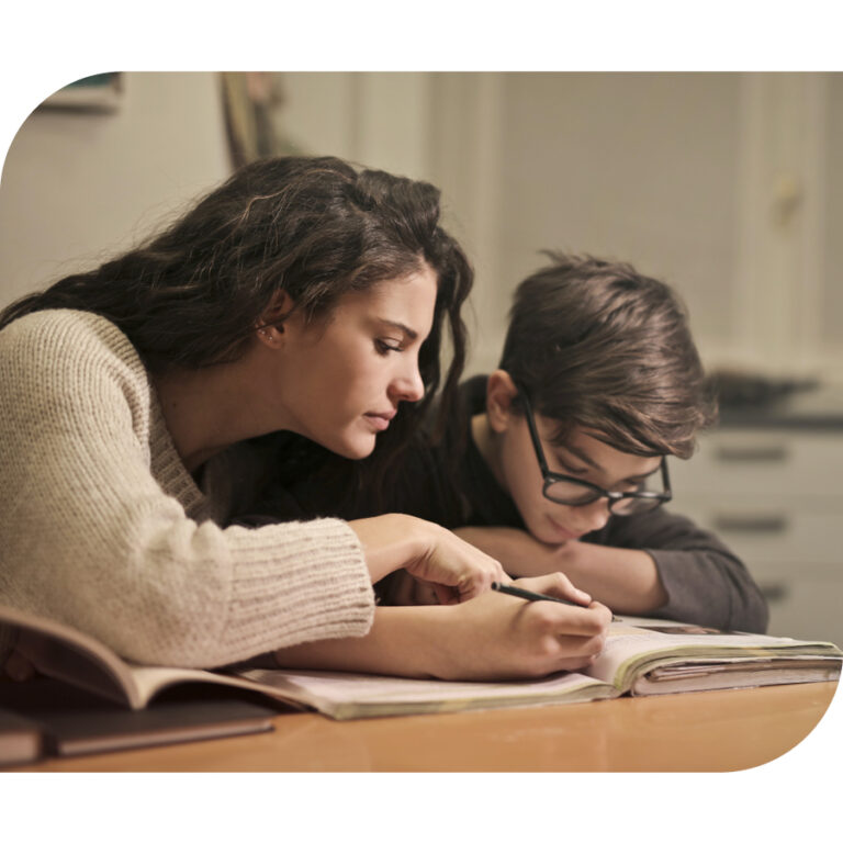 Mom looking at book with pre-teen boy