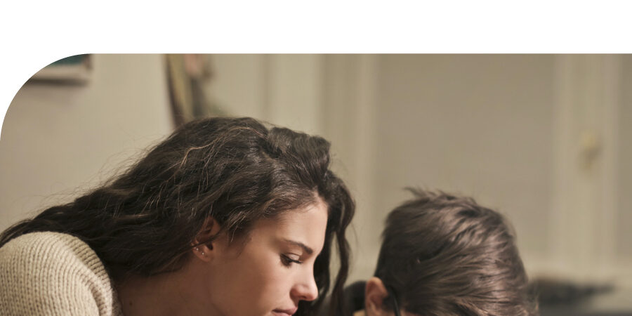 Mom looking at book with pre-teen boy