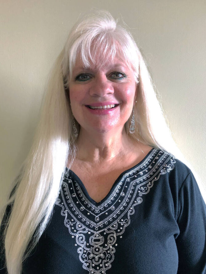 Woman smiling at camera with long blonde hair