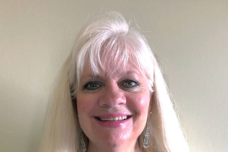 Woman smiling at camera with long blonde hair