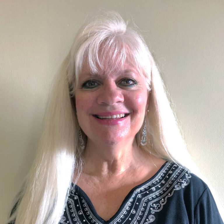 Woman smiling at camera with long blonde hair