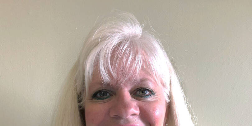 Woman smiling at camera with long blonde hair