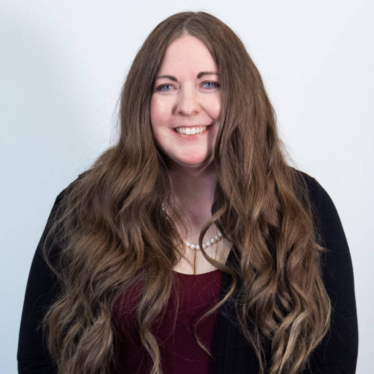 Woman with tailbone length brown hair and black cardigan