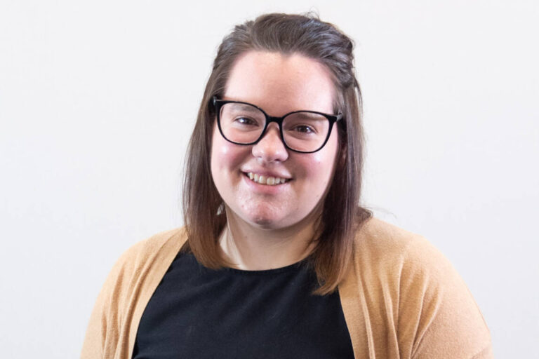 Headshot of woman with straight brown shoulder length hair and glasses
