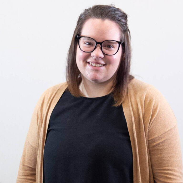Headshot of woman with straight brown shoulder length hair and glasses