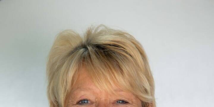 Photo of woman with blonde ponytail and bright purple floral top