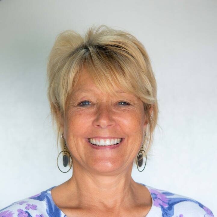 Photo of woman with blonde ponytail and bright purple floral top