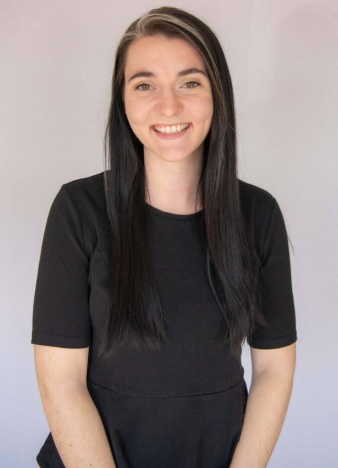 Woman smiling with long black hair and black shirt