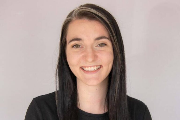 Woman smiling with long black hair and black shirt