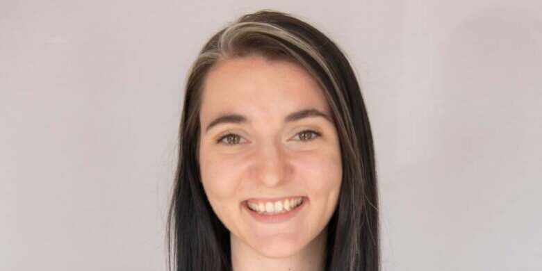 Woman smiling with long black hair and black shirt