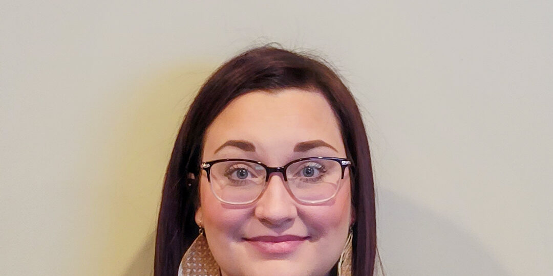 Amberae-Tauer-Blog-Photo Headshot of woman with dark brown/red hair and glasses with large earrings