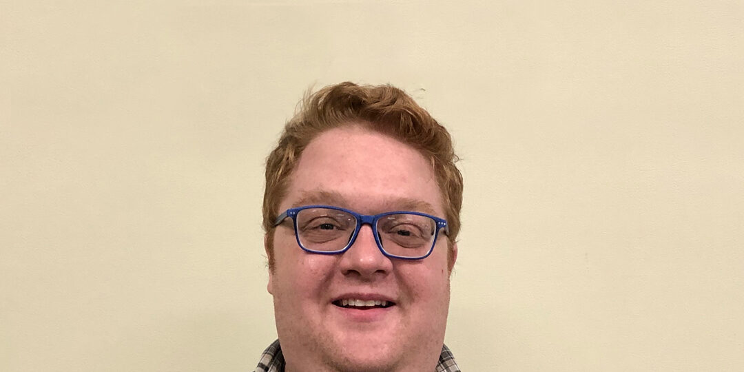 Paul-Workman-Blog-Photo Headshot of man with blue hair and plaid top