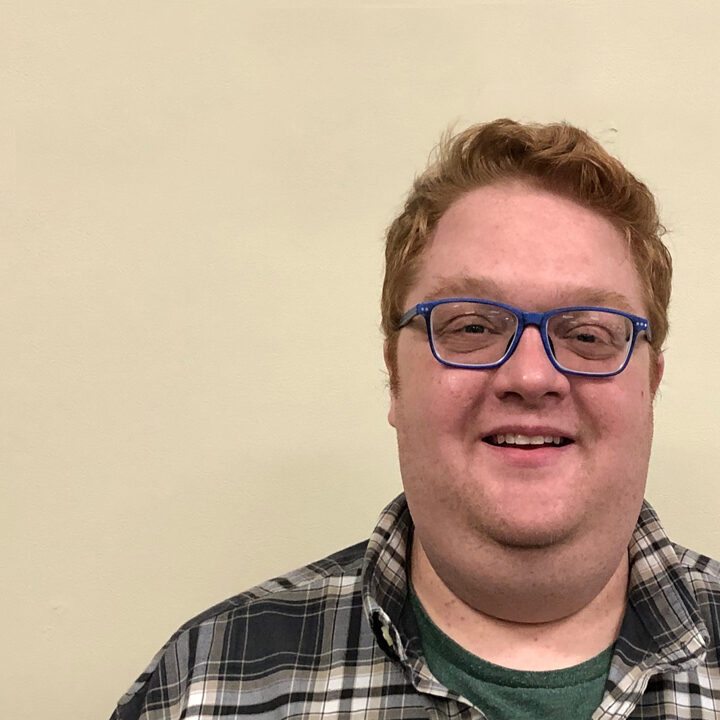 Paul-Workman-Blog-Photo Headshot of man with blue hair and plaid top