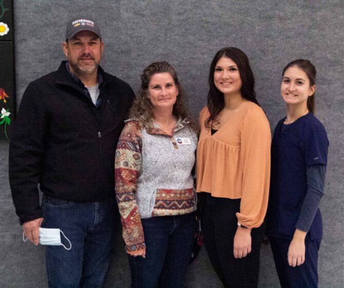 4 people standing together smiling