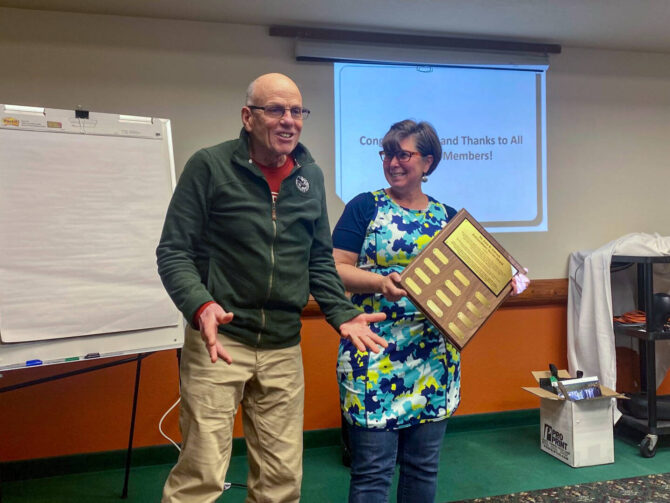 Dr. Schrock 05-2022 Dr. Schrock smiling in front of projecter presentation