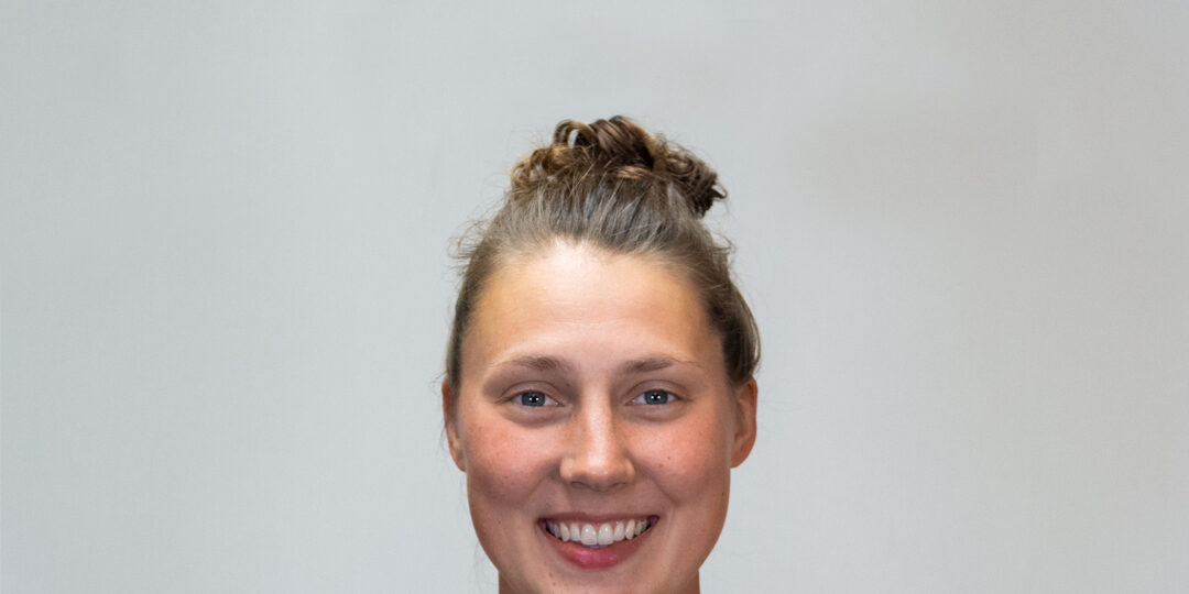 Claire-Tomashek-Blog-Post Headshot of woman with light brown shirt and messy bun