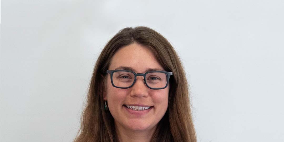 Headshot of woman with brown medium length hair and black glasses