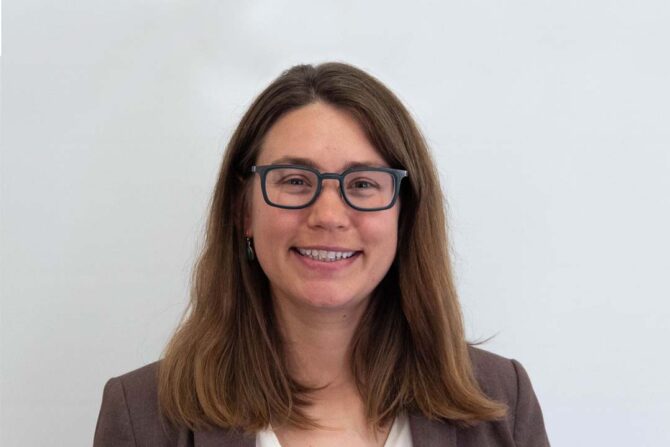 Headshot of woman with brown medium length hair and black glasses