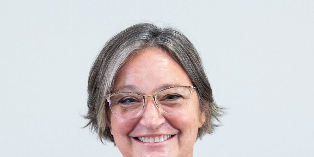 Headshot of woman smiling with glasses and short hair