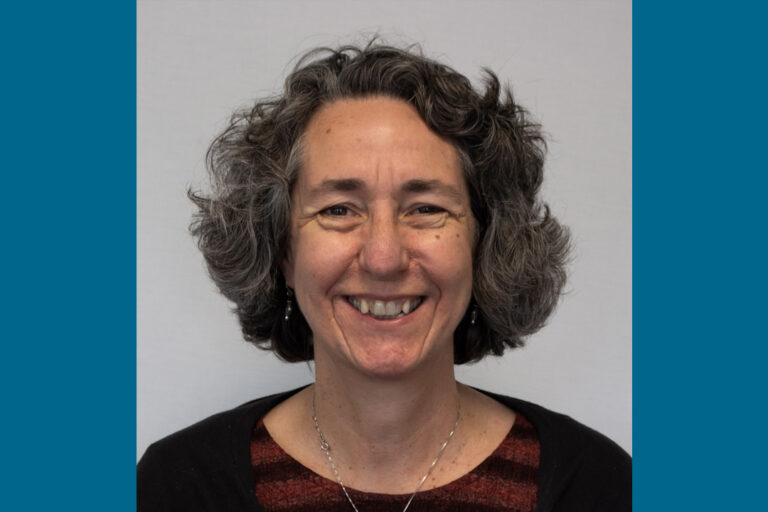 Headshot of woman with dark gray ear-length hair and big smile