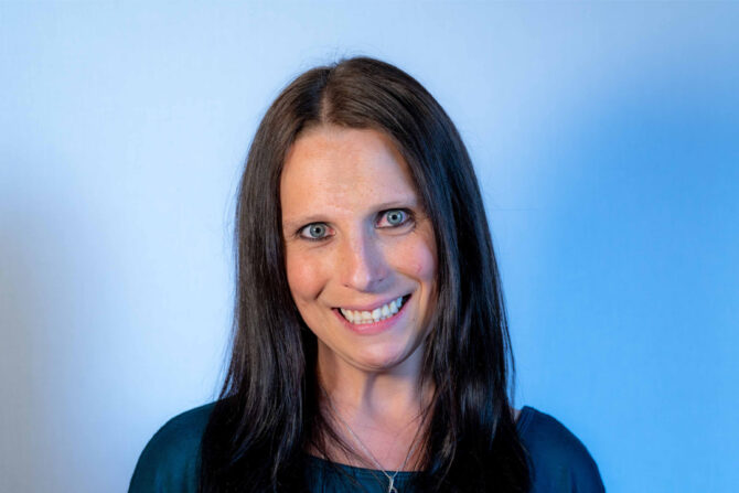 Headshot of woman with light blue eyes and dark long hair