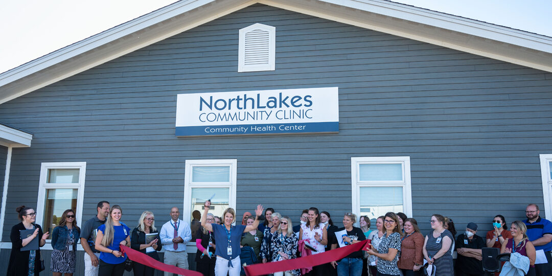 Turtle Lake ribbon cutting outside of building and red ribbon