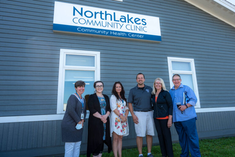 Staff members smiling in front of Turtle Lake Clinic building