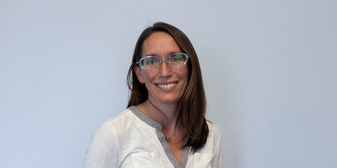 Headshot of woman with medium length brown hair and glasses