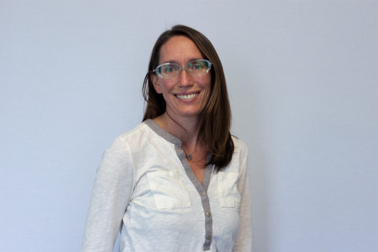 Headshot of woman with medium length brown hair and glasses