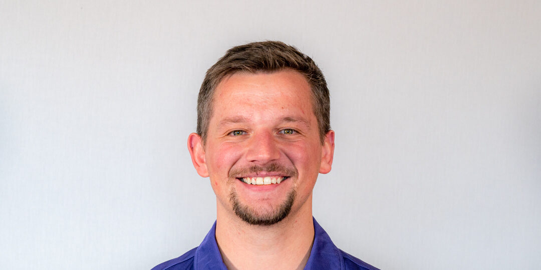 Tanner-Kleppe-Featured-Image-Blog-Post Headshot of man with dark blue shirt and short brown hair