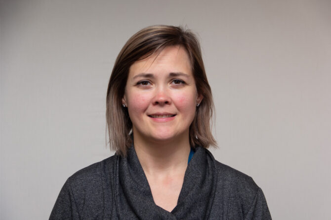 Headshot of woman with short brown hair and gray top