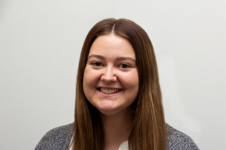 Headshot of woman smiling with long brown hair