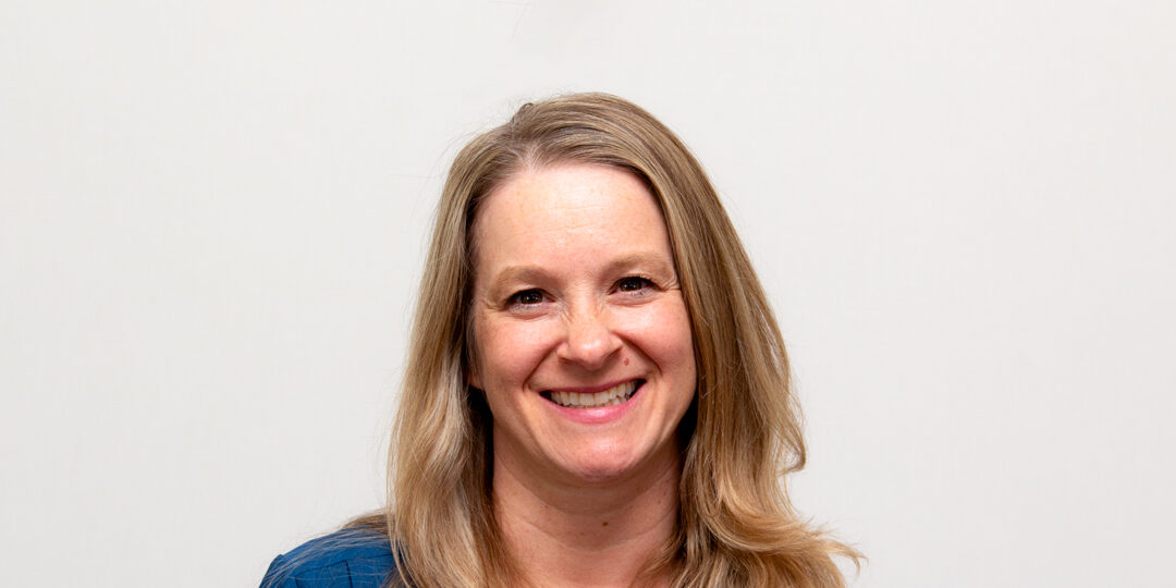 Headshot of woman smiling with long blonde hair and blue blazer