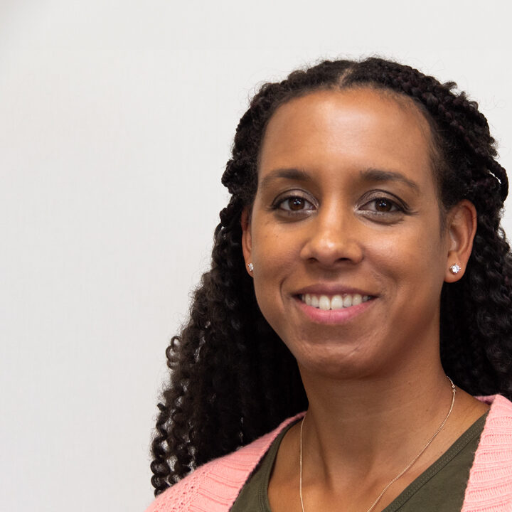 Ashli-Srmek-Featured-Image Headshot of woman with dark curly hair smiling at camera