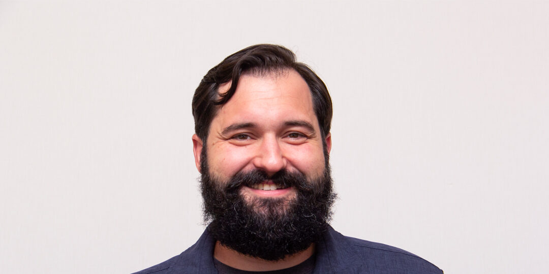 Headshot of man with dark hair and beard